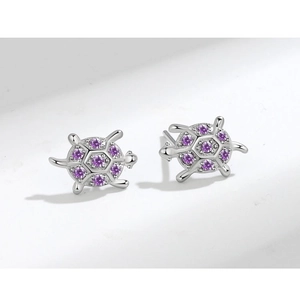 Dettaglio di orecchini a lobo a forma di tartaruga in argento con zirconi viola incastonati