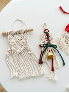 Detailed close-up of handmade macrame Christmas tree ornament with cotton rope and golden bell
