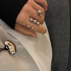 Detailed view of silver polished spherical beads on adjustable open rings for women