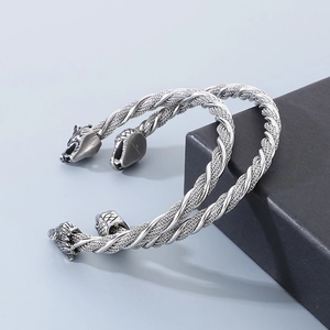 Détail du bracelet torsadé en acier 316L avec têtes de loup et de dragon gravées