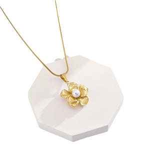 French vintage style camellia pendant necklace with pearl on a white geometric tray