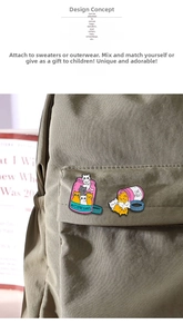 Macro shot of cute enamel cat pill bottle pins on a dark green canvas backpack