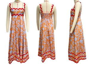 Detail view of floral print maxi dress with red wavy trim and elastic back smocking