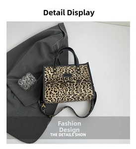 Close-up of leopard print tote bag with removable logo strap and white stitching detail