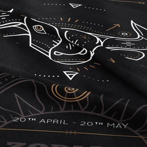 Close-up of black Taurus zodiac tapestry fabric showing knitted texture and gold bull print