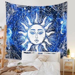 Detail of blue sun and moon tapestry hanging as a bohemian wall decoration in a bedroom