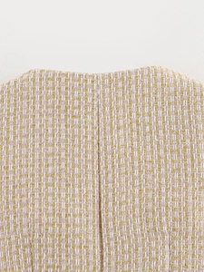 Macro detail of beige and white tweed fabric featuring elegant gold thread weaving texture