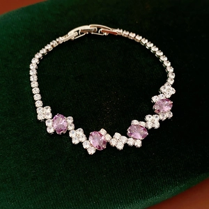 Macro view of geometric silver bracelet with pink zircon stones and crystal pave clasp
