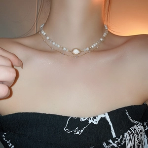 Detail of French vintage double-layer necklace with white pearls and gold oval pendant
