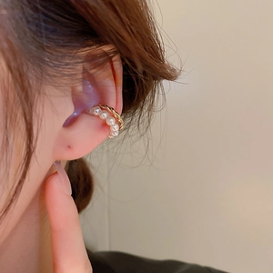Gold twisted double-layer ear cuff with pearls on a model in warm natural light