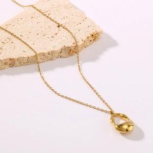 Minimalist 18K gold plated stainless steel hollow oval pendant necklace on a stone