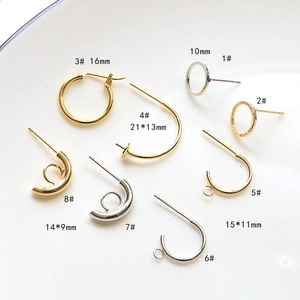 Macro shot of 18k gold plated C-shaped ear hoops and hooks in various sizes with labels