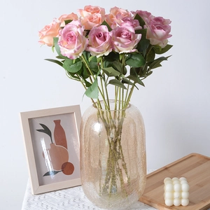 Pink and purple artificial silk roses in a decorative glass vase for home wedding decor