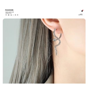 Close-up of vintage silver snake earrings showing detailed scales and textured finish