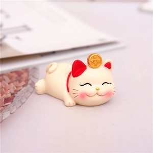 Macro shot of a cute cream-colored lucky cat resin figurine with gold coin detail