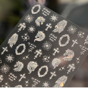 Holographic nail sticker detail featuring horse head, crosses, and radiant star motifs