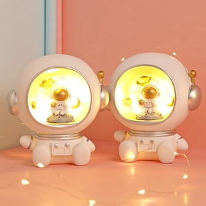 Astronaut night light featuring golden figure and glowing planet with warm light effect