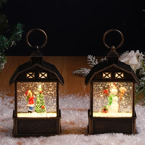 Close-up of bronze Christmas lanterns with warm LED lighting and miniature snow scenes