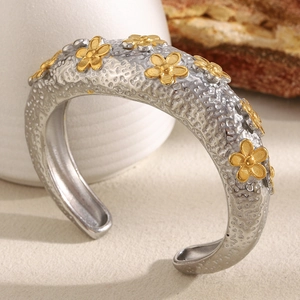 Vintage silver hammered cuff bracelet featuring small gold flower accents and open design