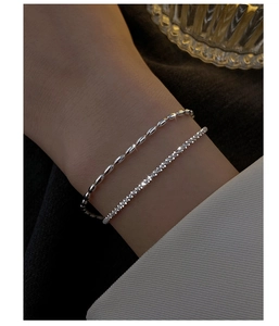 Close-up of double-layer silver bracelet featuring minimalist beads and sparkling zircons