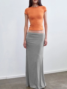 Detail of fitted orange crew neck t-shirt and grey low waist maxi skirt for women