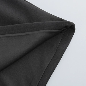 Gros plan sur la texture du tissu noir et le drapé d'une robe de soirée élégante