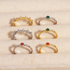Detail of six adjustable zircon-set rings in gold and silver finish on a display tray