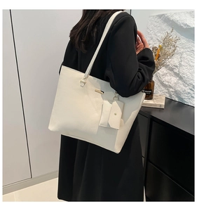Detail showing creamy white pebbled leather tote bag and matching zipper charm pouch