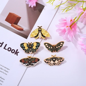 Detailed view of alloy butterfly enamel pins with vintage floral and celestial patterns