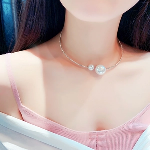 Close-up of sparkling rhinestone choker with elegant imitation pearls on a model's neck