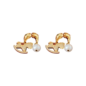 Elegant gold rocking horse earrings with pearls and crystals on white background