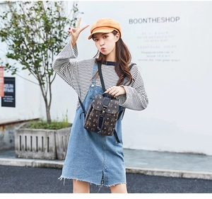 Outdoor street style shot of a brown mini backpack with classic monogram and drawstring