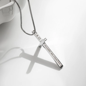 Détail du pendentif croix en argent avec verset biblique gravé sur une chaîne serpent