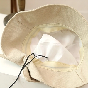 Detail view of the interior lining, texture fabric, and black windproof strap of the sun hat