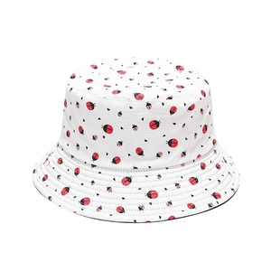 White bucket hat with red ladybug pattern and wide brim for outdoor sun protection
