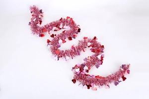Detail of festive heart tinsel garland with red and pink sequins for party decoration
