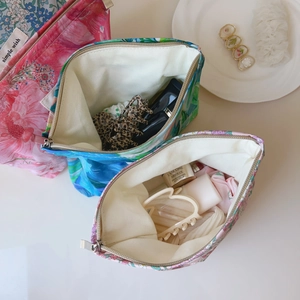 Interior view of floral canvas makeup pouch with zipper closure and logo label