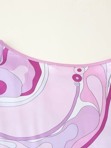 Detail des rosa-violetten Wirbelmusters am Ausschnitt eines Satin-Boho-Kleides