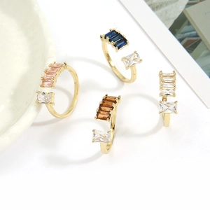 Detail of four colorful rectangular cubic zirconia open rings with gold finish base