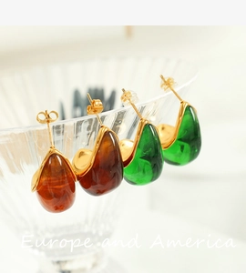 Detailed view of amber and emerald teardrop resin earrings with 18K gold base