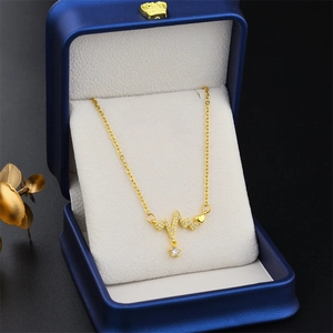 Golden heartbeat necklace with heart and star zircon pendant in a blue jewelry box