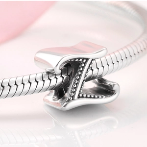 Macro shot of silver letter Z charm with beaded texture on a snake chain bracelet