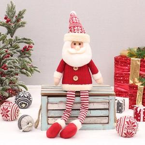Detail of plush Santa Claus figure with long soft legs sitting on a vintage wooden box
