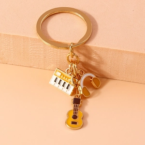 Detailed view of music-themed keychain with enamel piano, guitar, and headset charms