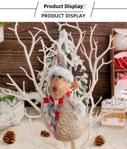 Detail of a Nordic knitted reindeer ornament hanging on a festive branch with warm decor