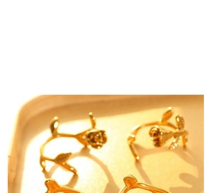 Close-up of 18k gold-plated 3D rose flower earrings with delicate stems and petals