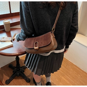 Detail of vintage brown crossbody bag with suede patchwork and gold buckle in cafe