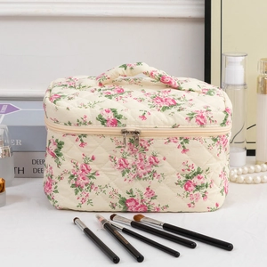 Detail of floral quilted cotton makeup bag featuring dual zippers and sturdy top handle