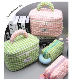 Close-up of pink quilted makeup bag with Melody embroidery and green toiletry pouch