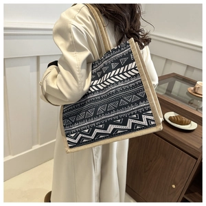 Detailed texture of geometric pattern tote bag with woven jute handles on woman's shoulder